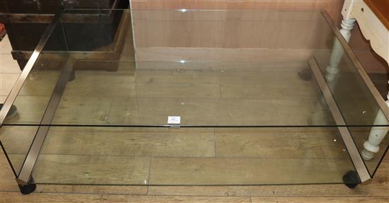 A modern chrome edged two tier plate glass coffee table, on castors W.136cm